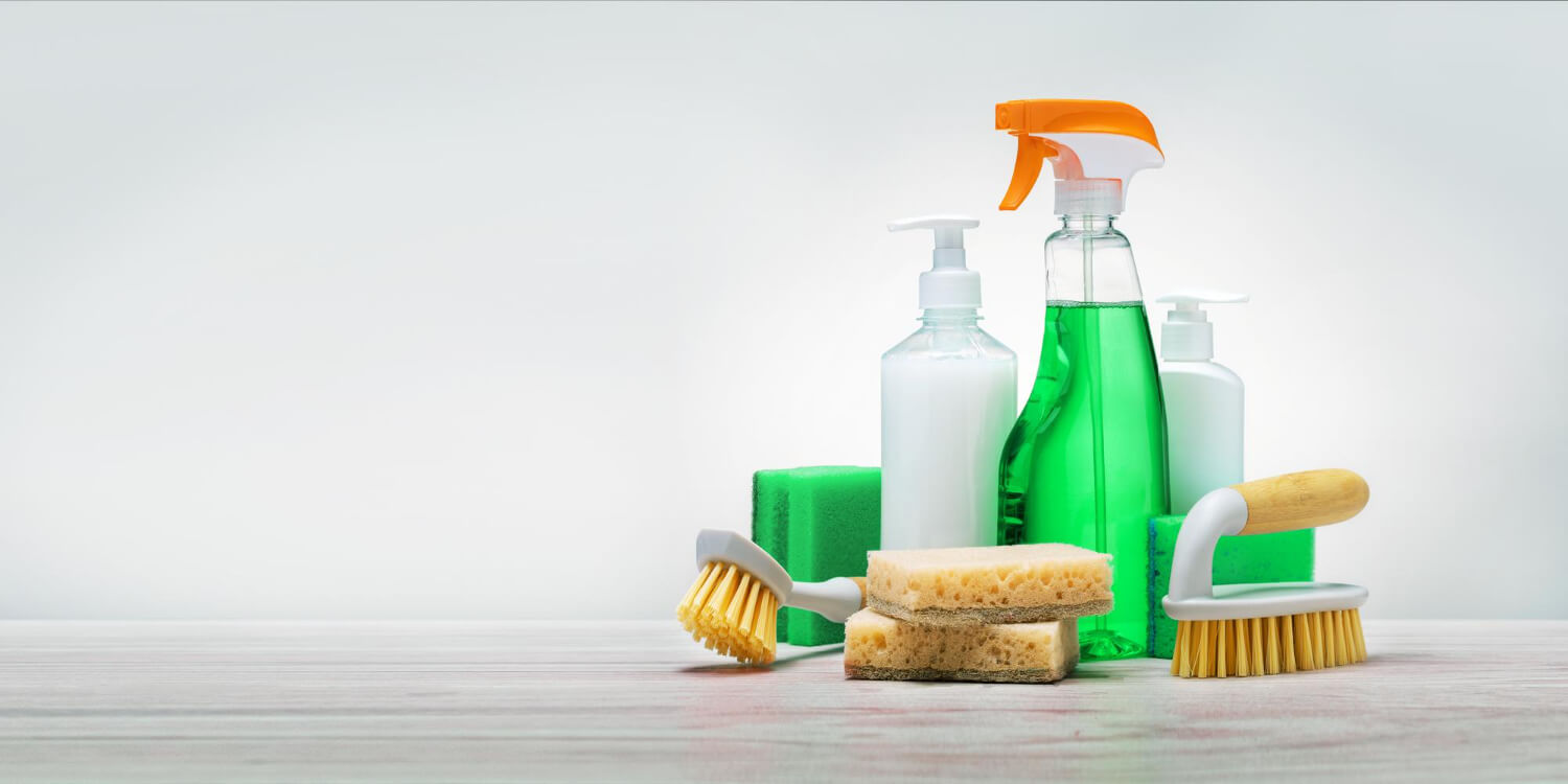 various cleaning products and cleaning supplies on table