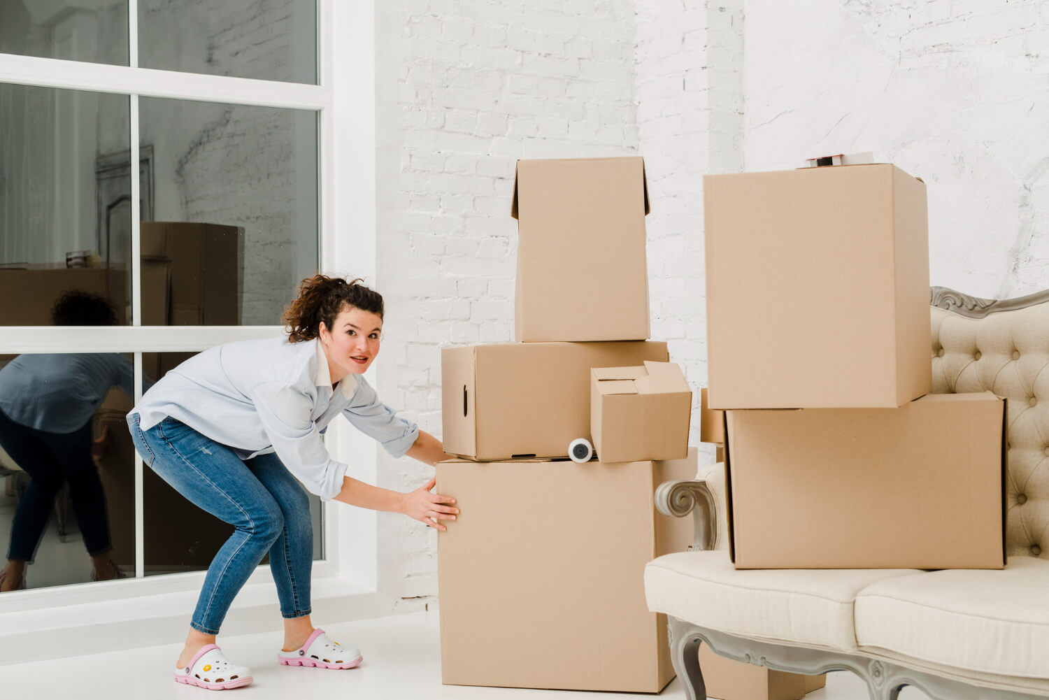 pretty woman pushing staffed moving boxes for relocation reasons