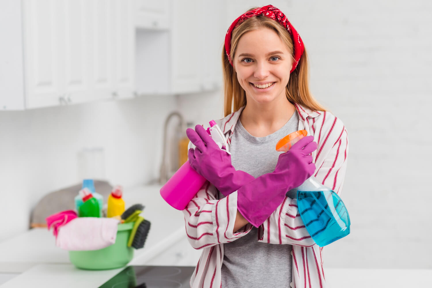 young woman in red headband and purple gloves smilling on camera prepared for cleaning while holding cleaning equipment