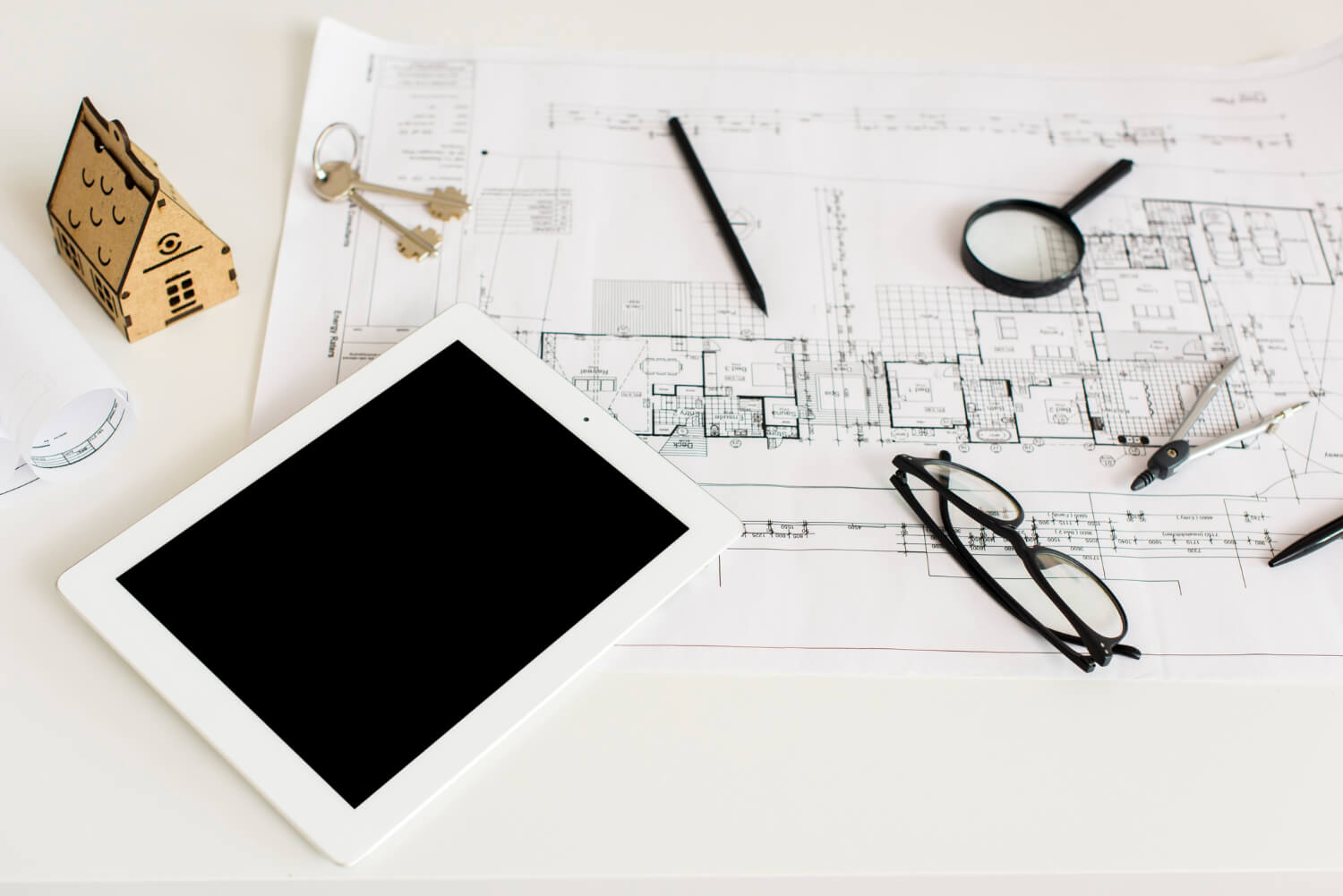property plans tablet and keys on desk for property marketing