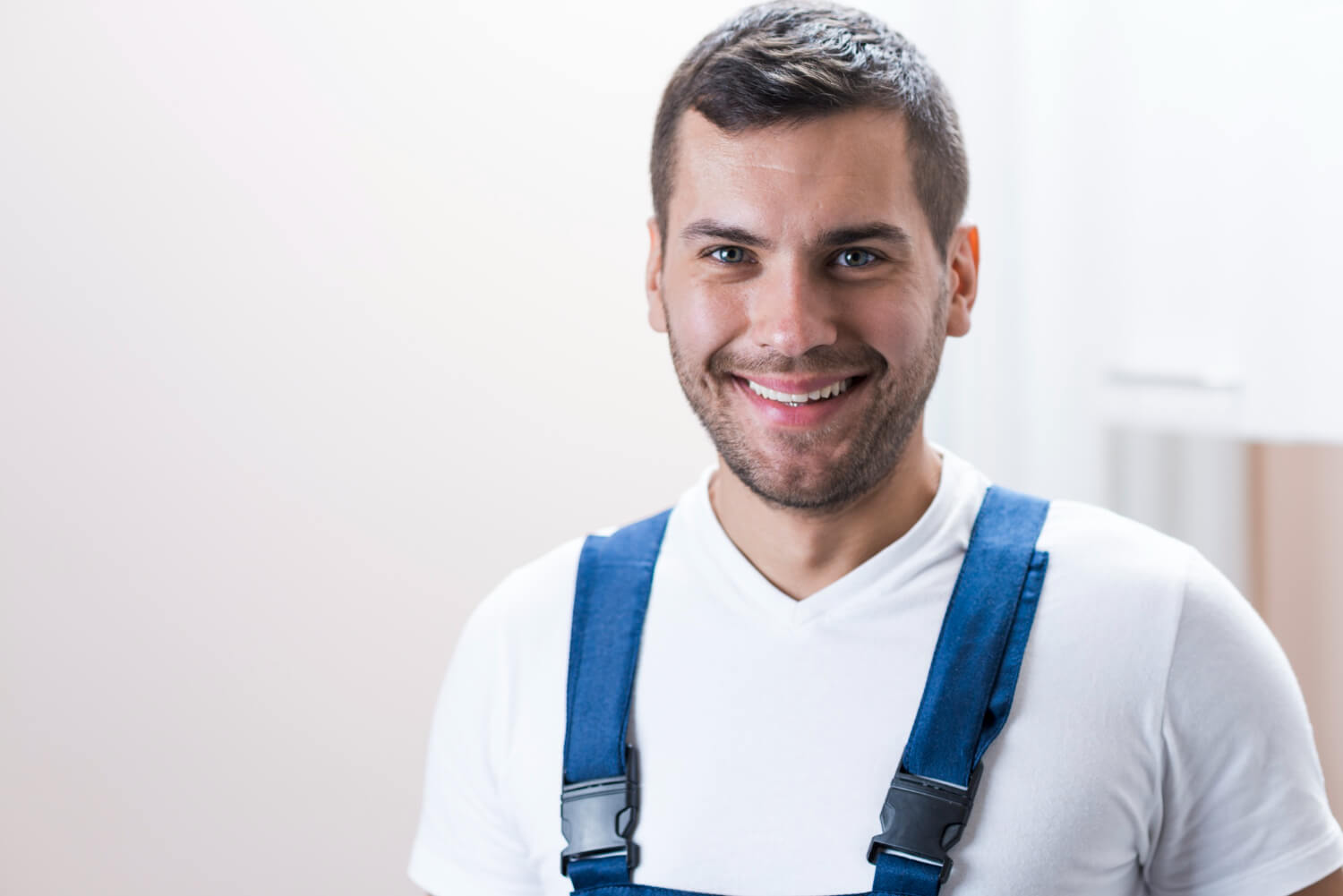 plumber closeup smiling in blue uniform