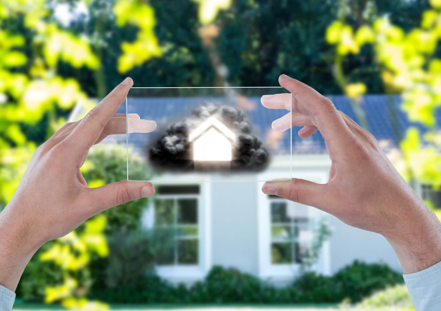 front view of a house with man's hands holding a cloud futuristic device with a house on it