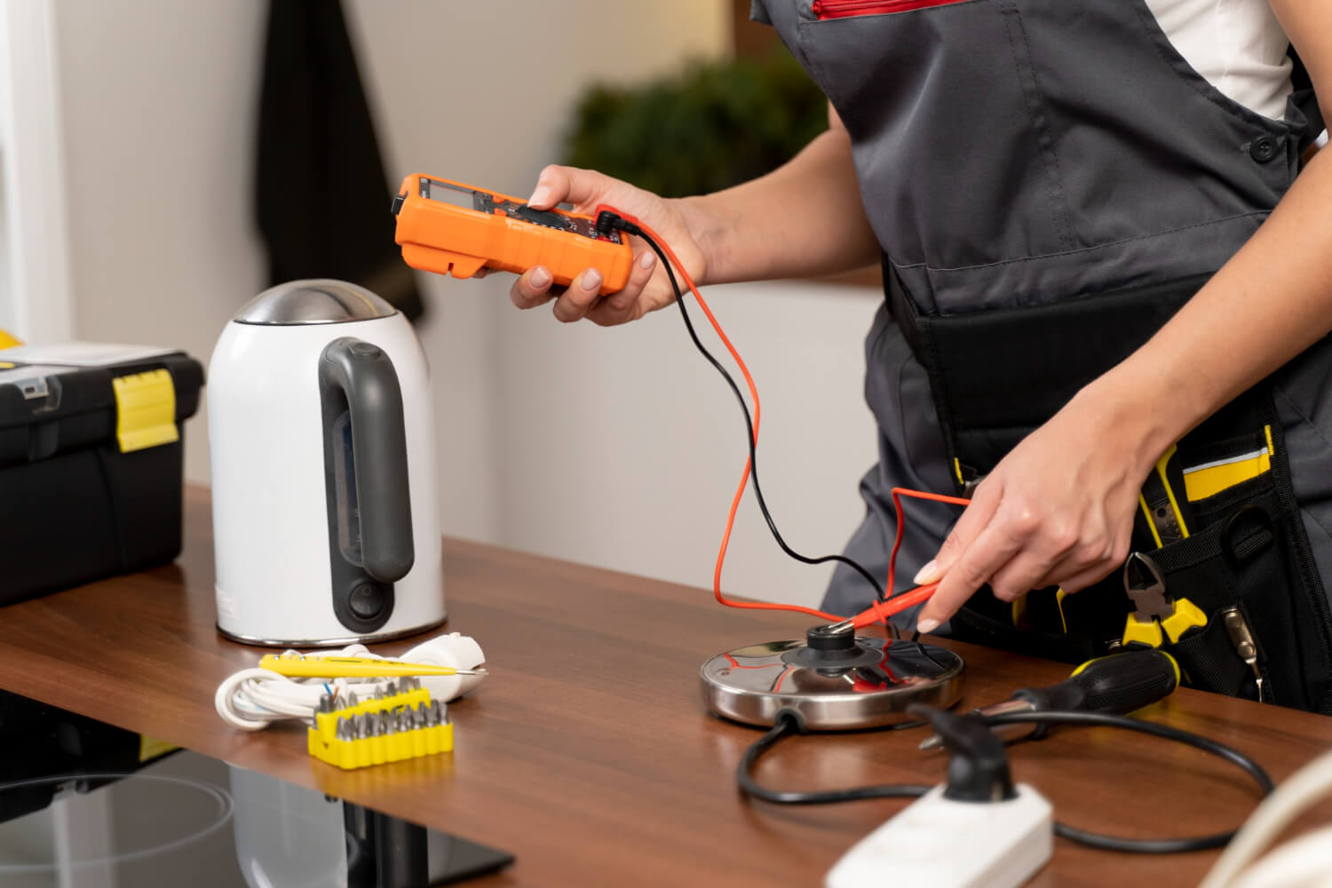 close up cropped electrician performs portable appliance testing on electric appliance