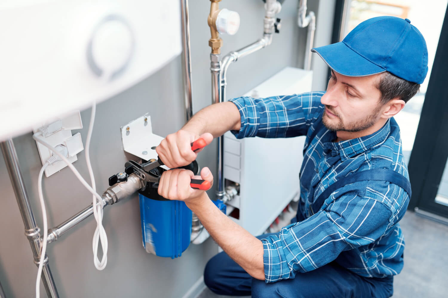 top view of plumber using pipes while installing boiler in home