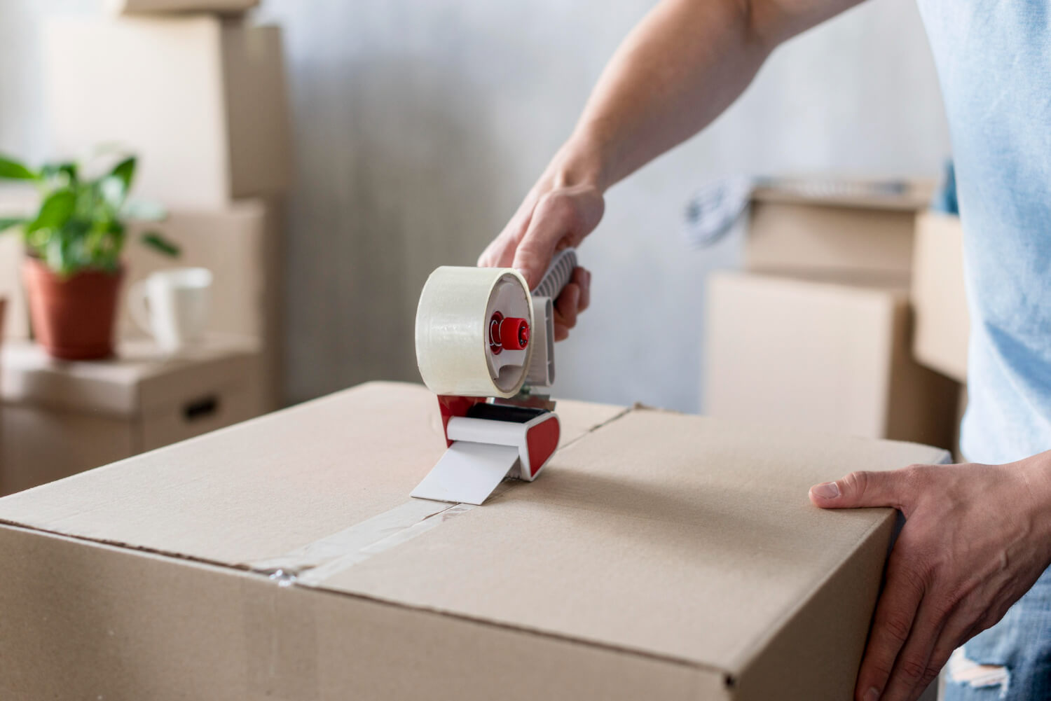 man using tape box on moving box for house removal