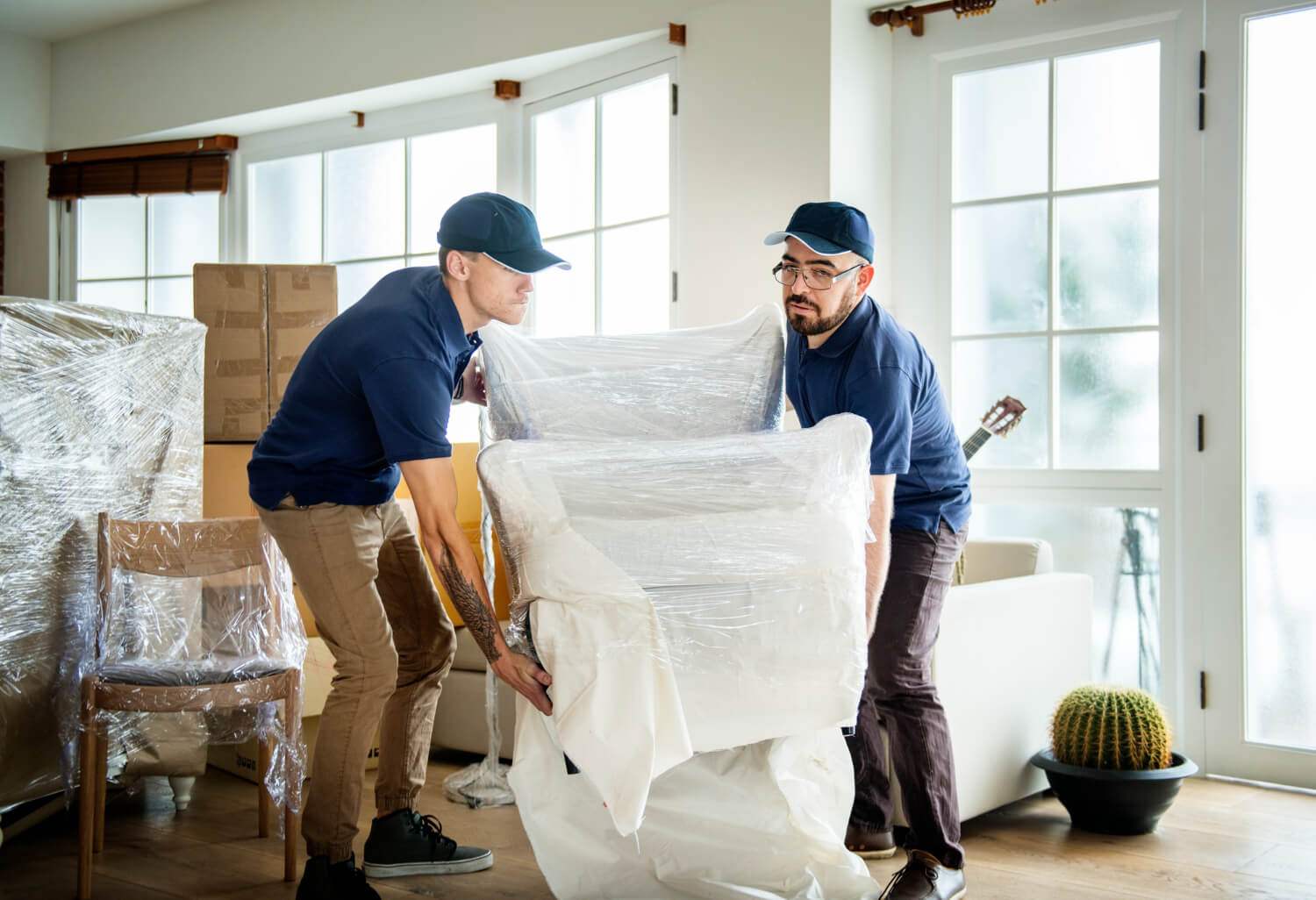 front view of two movers holding wrapped chair for moving out