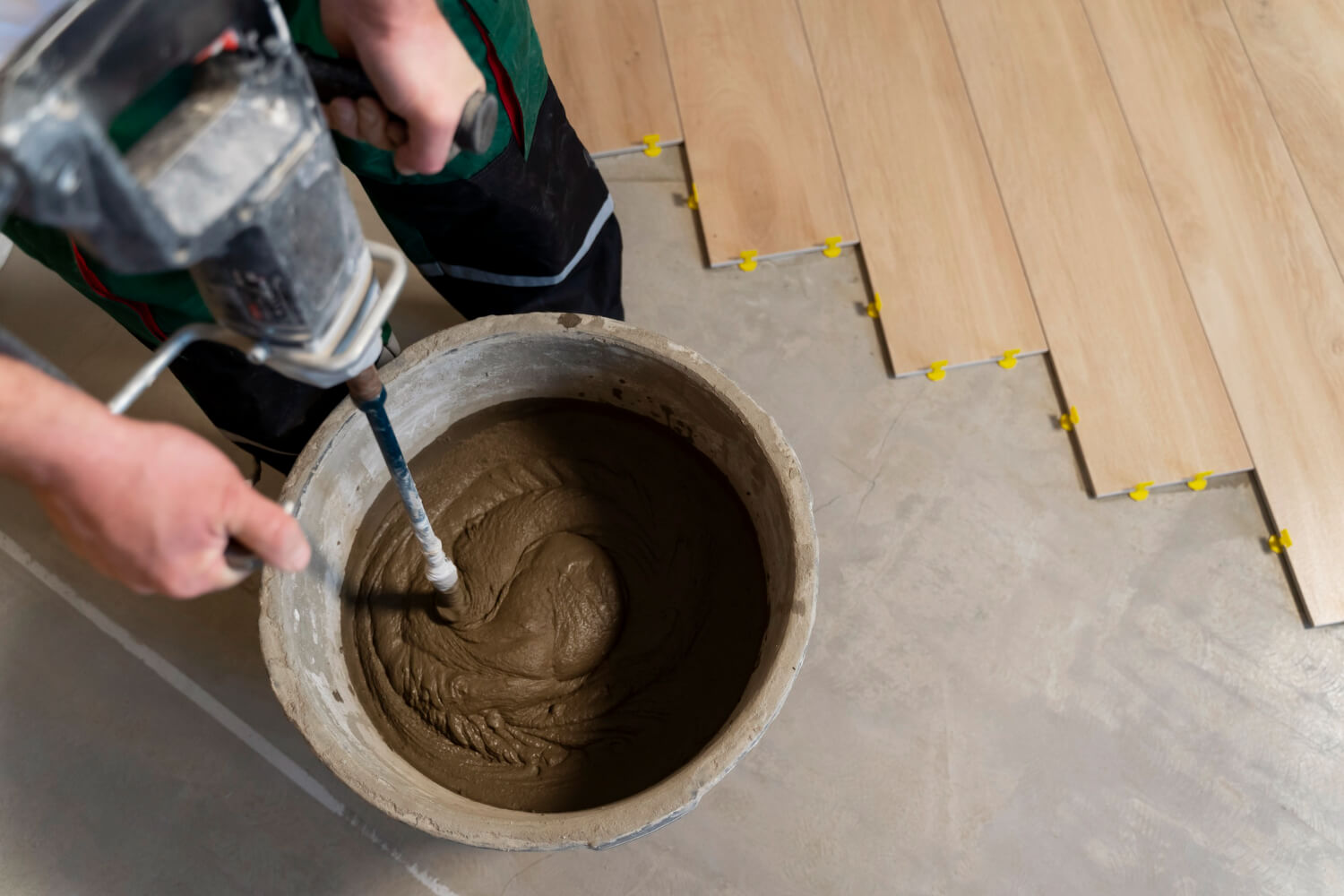 cropped handyman mixing cement for floor sanding