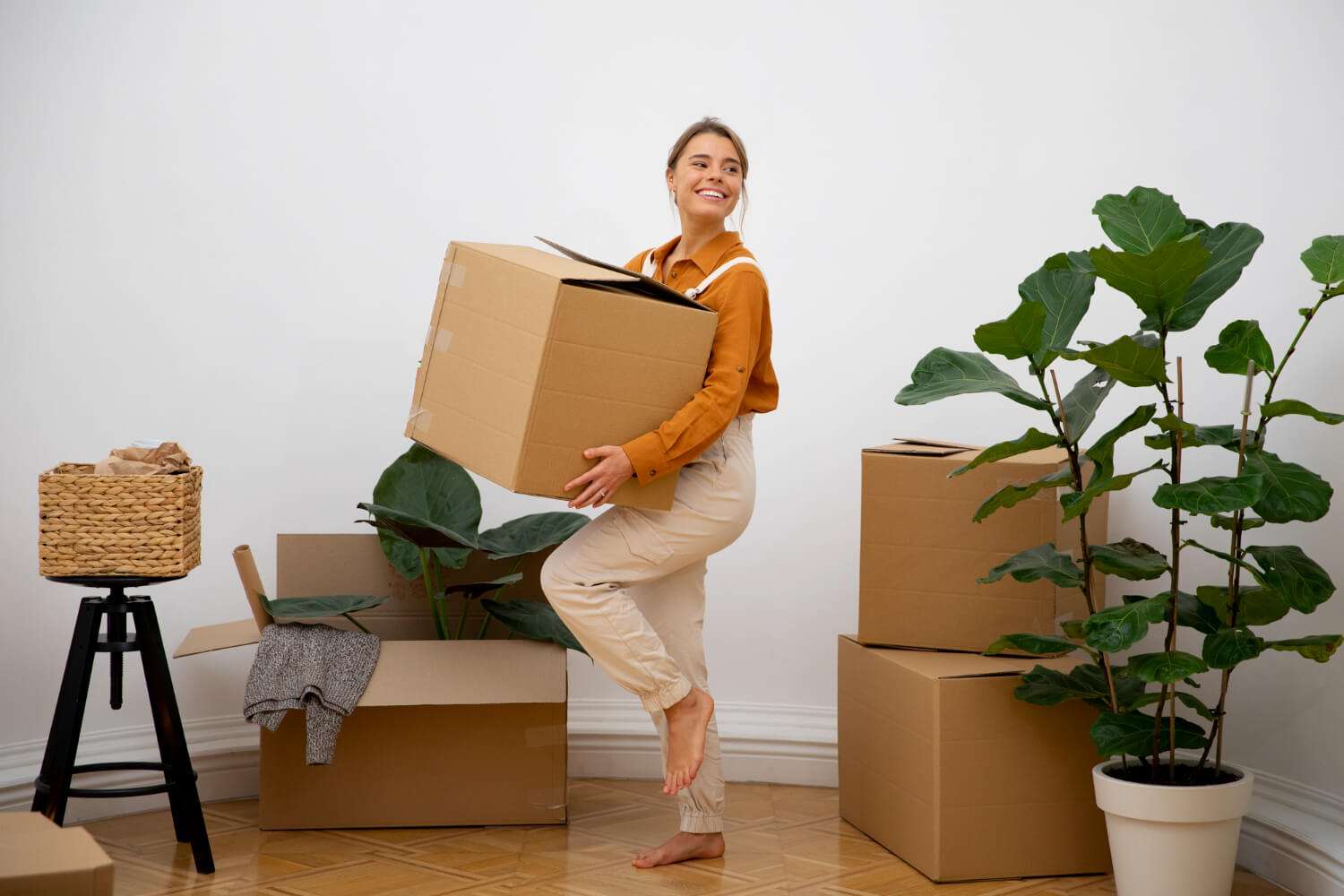 young happy woman holding moving boxes from her apartment